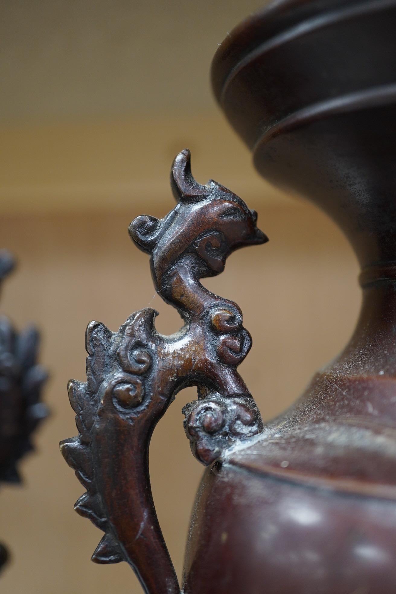 A pair of Japanese two handled bronze vases decorated in relief with birds and flowers, 26cm high. Condition - good